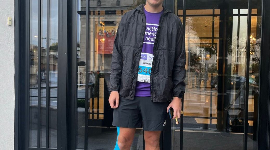 Matthew before the race, wearing his purple AMH top and race number, running shoes and sports tape on his knee.