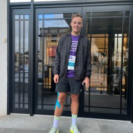 Matthew before the race, wearing his purple AMH top and race number, running shoes and sports tape on his knee.